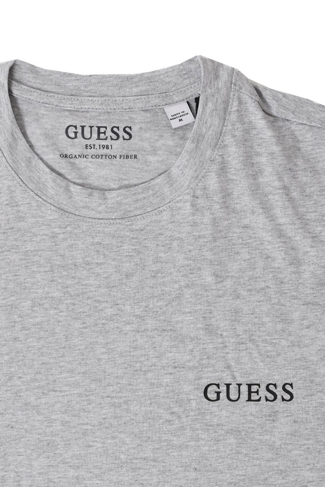 Maglietta Guess Jeans per uomo in cotone grigio con logo stampato, maniche corte e taglio dritto. Comfort e stile per ogni occasione.